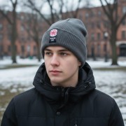 Czapka zimowa Dywizjon 303 na głowie młodego mężczyzny